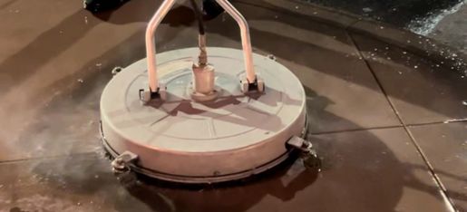 A surface cleaner washing a concrete patio